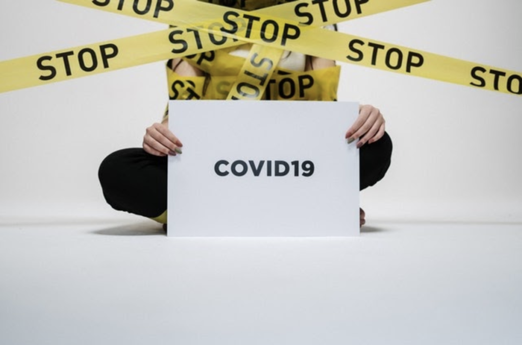 Een vrouw houdt een bordje vast met COVID-10 er op.
