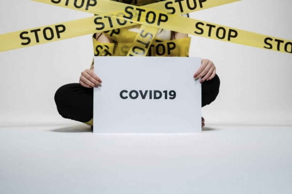Een vrouw houdt een bordje vast met COVID-10 er op.